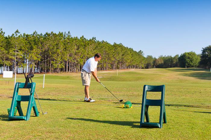 Golfer practicing at the driving range at Highlands Reserve