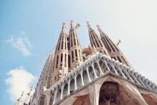 Looking up at the large towers of the Sagrada Familia in front of a blue sky