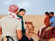 Guests enjoying a camel ride through the Dubai desert