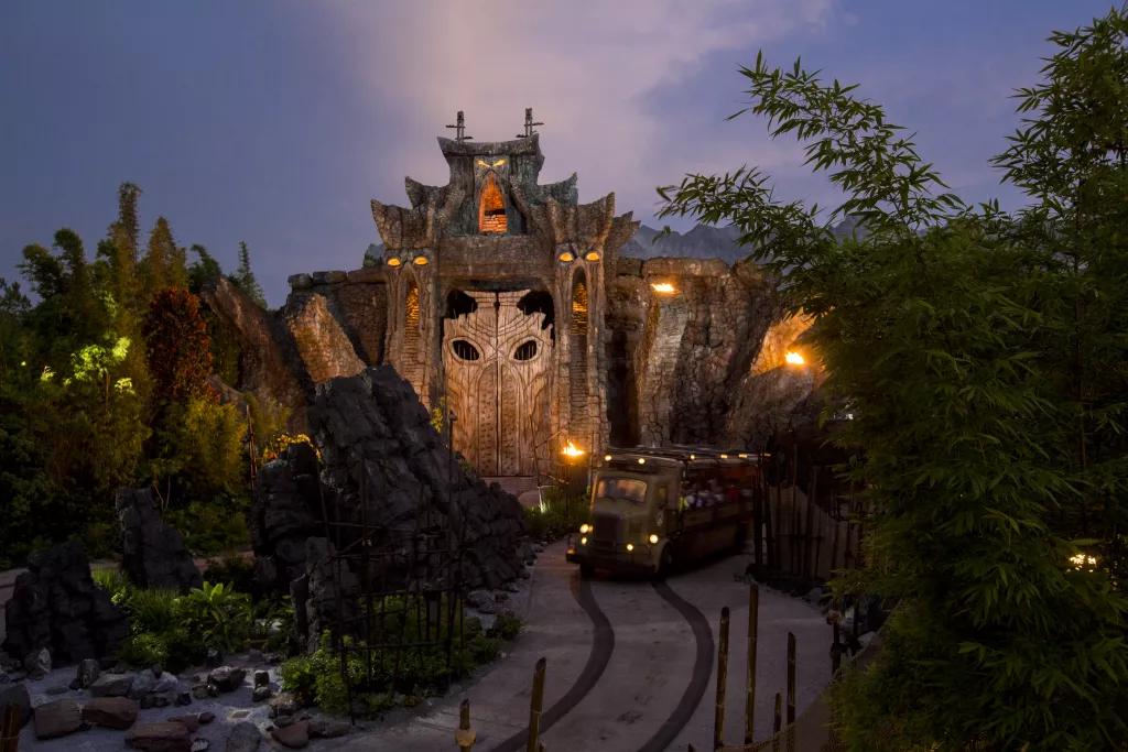 A ride vehicle going along a track on Skull Island: Reign of Kong