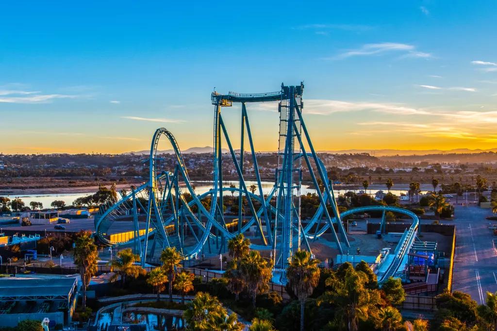An aerial view of the Emperor coaster at SeaWorld San Diego with a sunset in the background