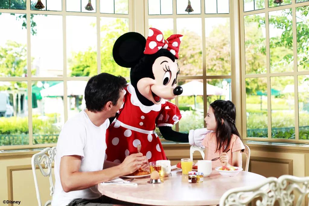 Minnie Mouse with two guests eating breakfast at Plaza Gardens Restaurant