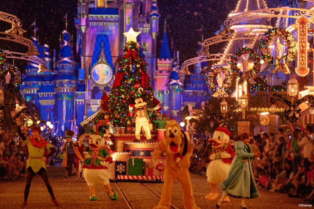 Pluto, Peter Pan, Wendy and other Disney characters walking down Main Street in the Christmas Parade