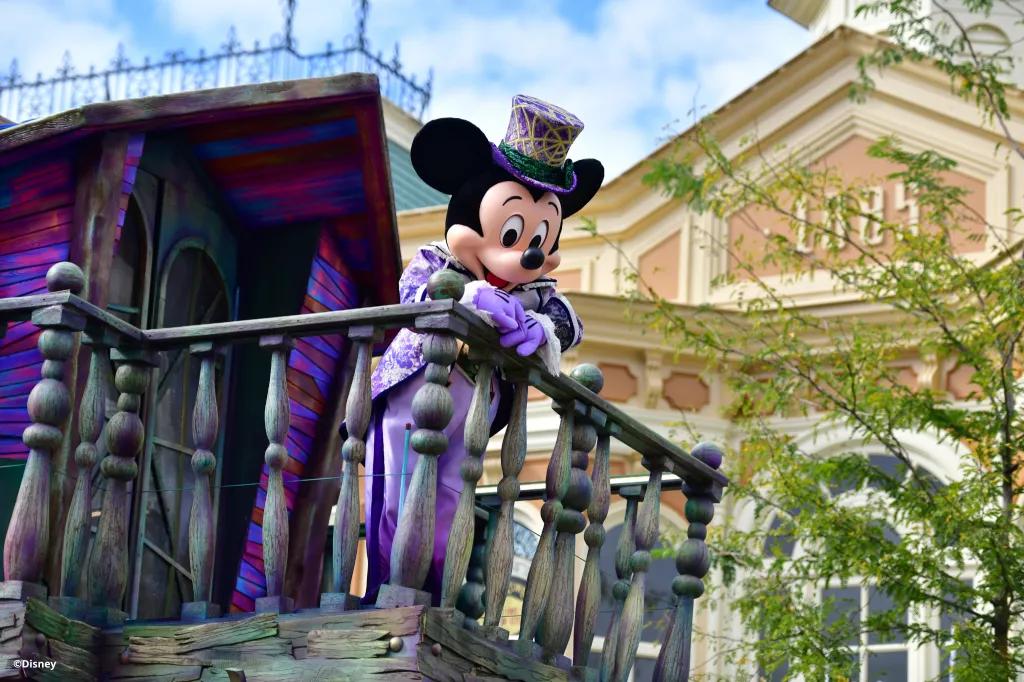 Mickey Mouse dressed in a distressed top hat and tails on a Halloween float