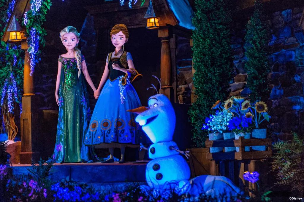 Anna and Elsa animatronics behind an Olaf animatronic on Frozen Ever After