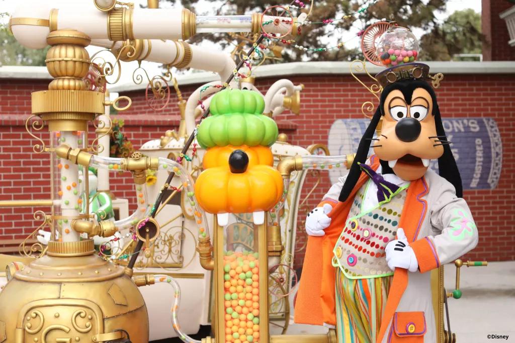 Goofy in a Halloween outfit standing next to a candy machine