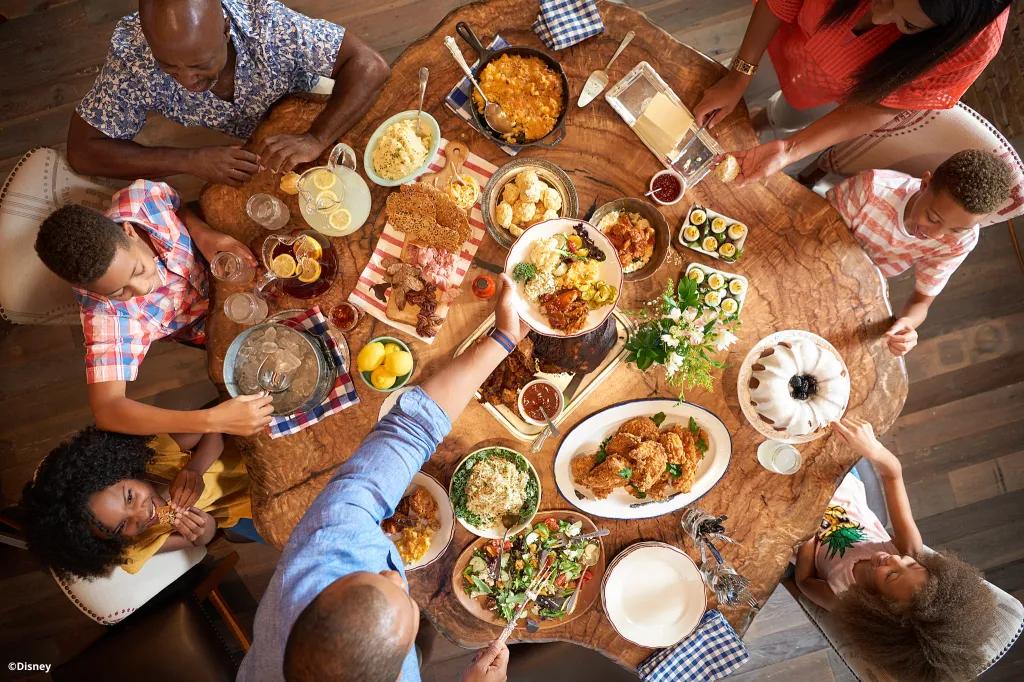 A family dining at a wooden table full of food