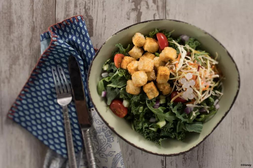 Bird's eye view of a tofu salad bowl on a wooden table
