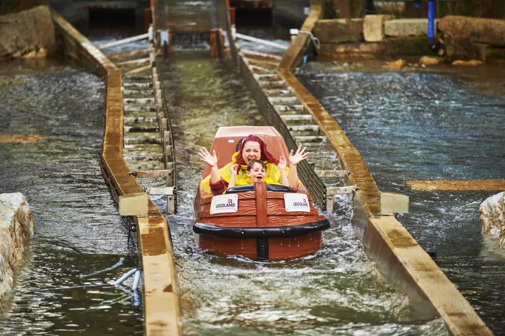 A woman and child soaking wet after dropping down on a log flume