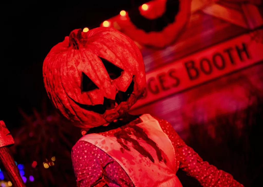 A woman in a bloody apron with a jack-o-lantern head