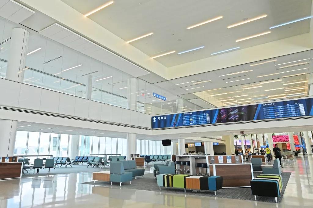 Chairs and benches at Terminal C below a screen showing departures and arrivals