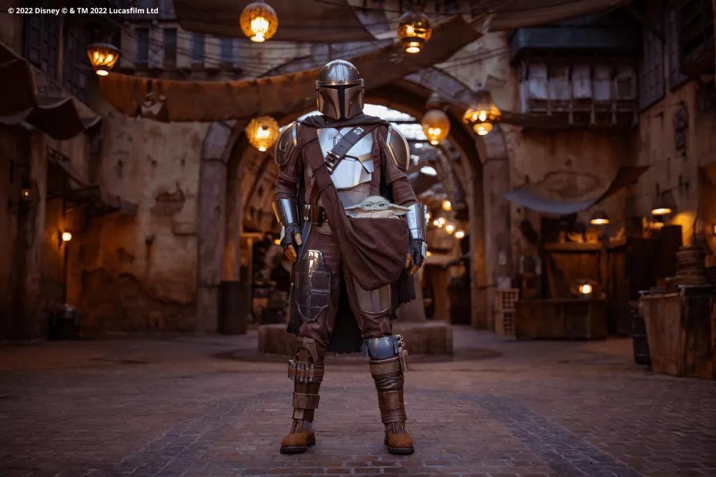 The Mandalorian in full armour standing in Star Wars: Galaxy's Edge