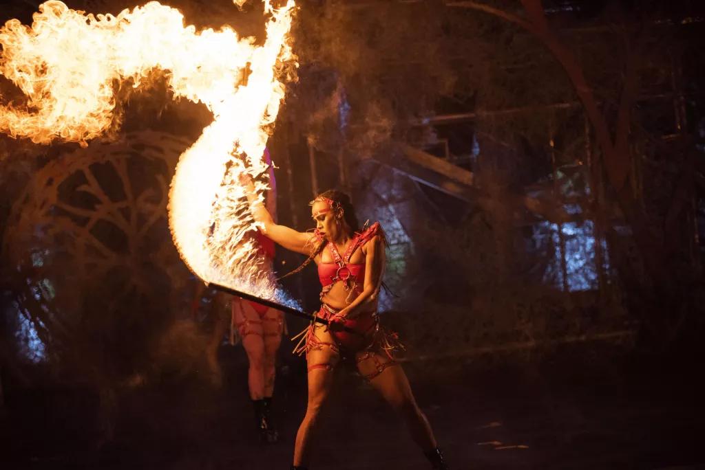 A female performer dancing with a sword that is on fire