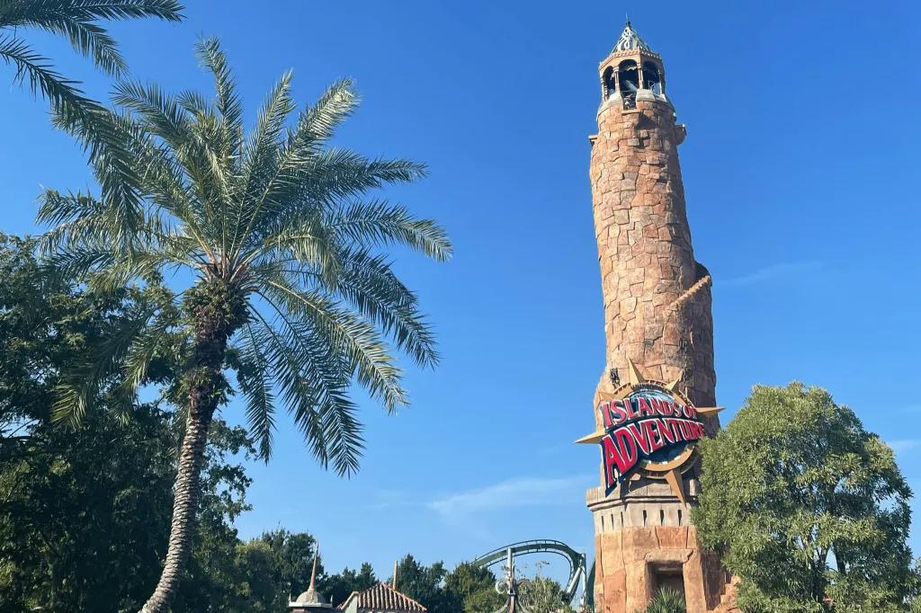 The entrance to Islands of Adventure in front of palm trees and a blue sky