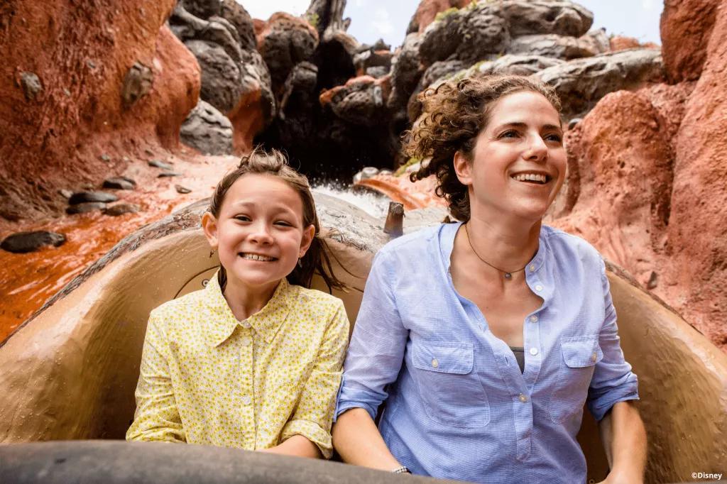A woman and young girl smiling while going down the drop on Splash Mountain