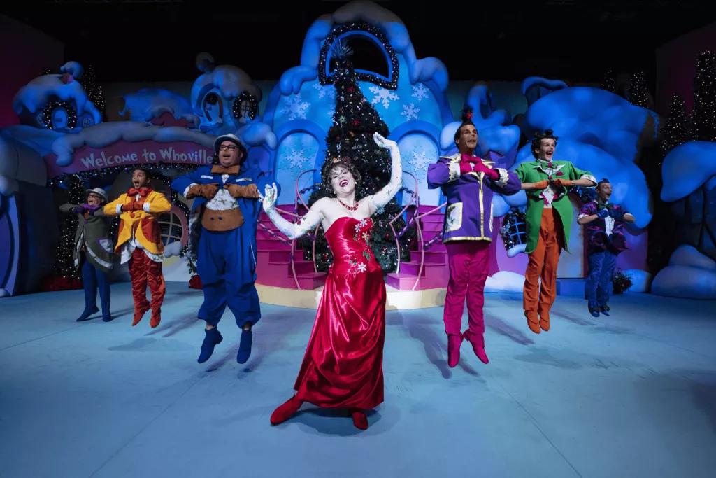 Performers dressed up as Whos from The Grinch singing and dancing on a stage