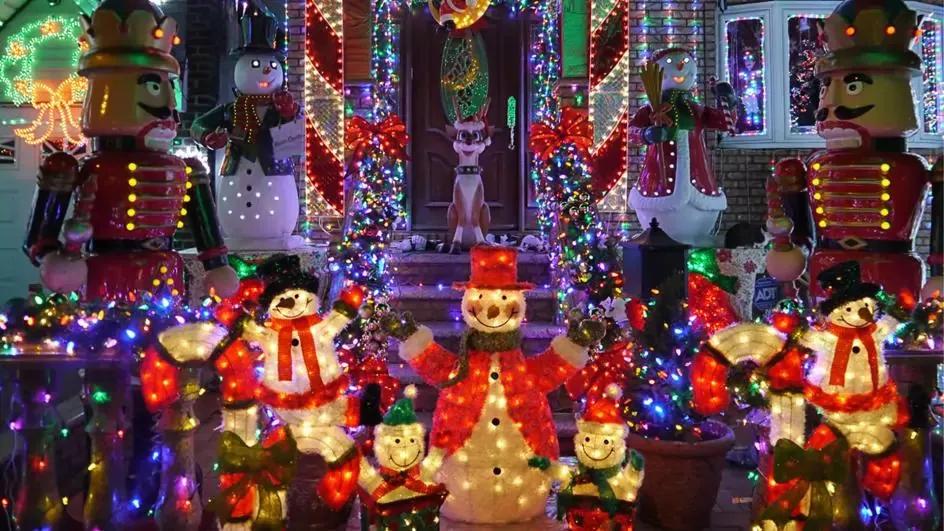 Light up Christmas decorations outside a house, including snowmen, nutcrackers and reindeer