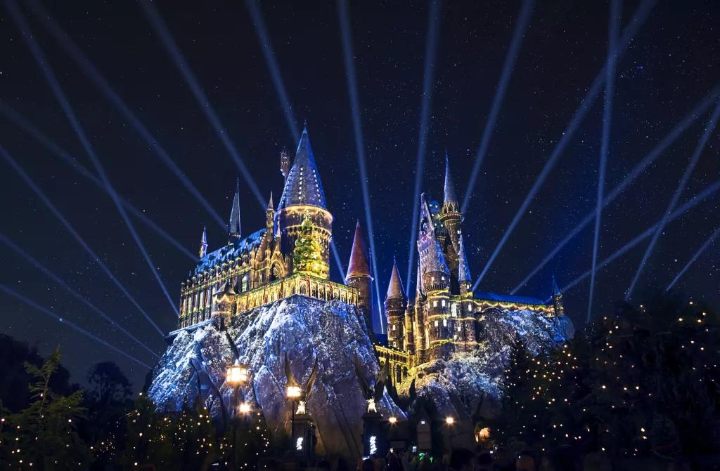 Hogwarts Castle at night lit up with Christmas projections