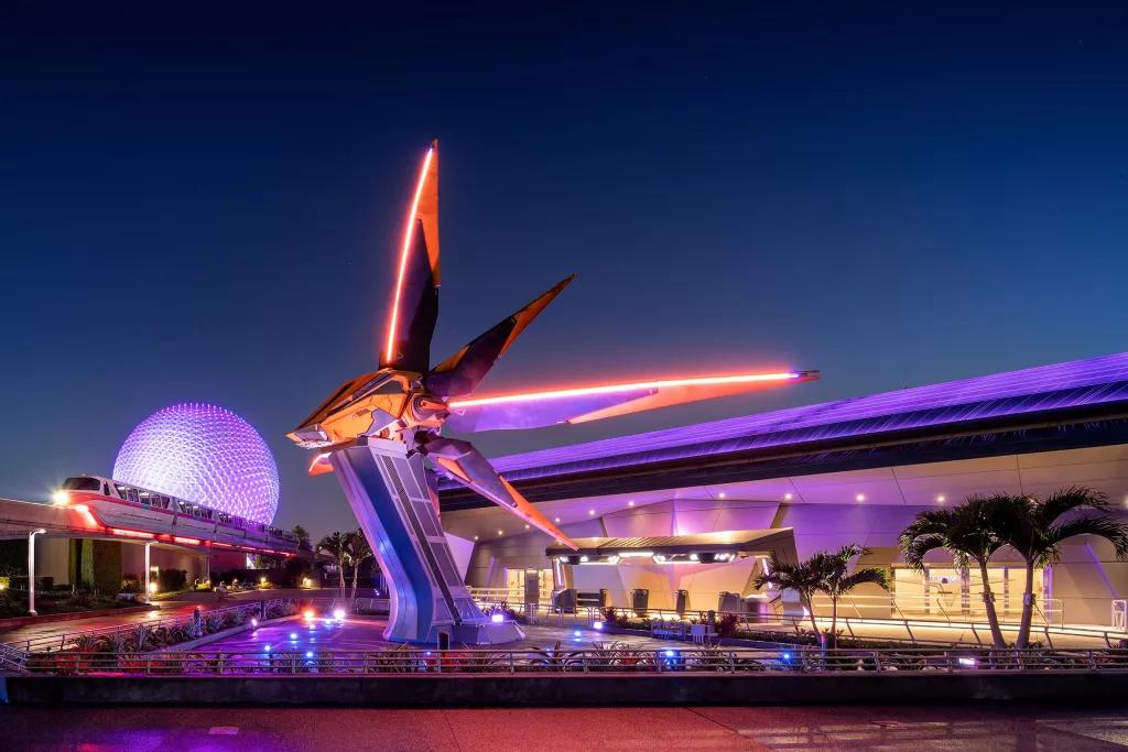 The exterior of Guardians of the Galaxy: Cosmic Rewind, with a large spaceship in front of Spaceship Earth and a monorail