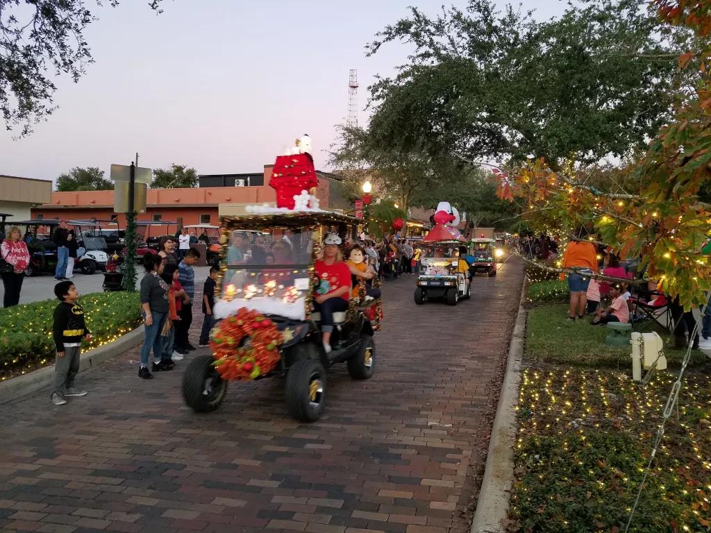 A parade of golf carts decorated with Christmas decorations