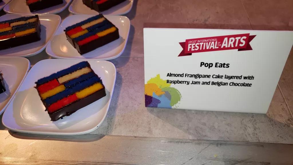 A row of cakes made of multicoloured layers on a table