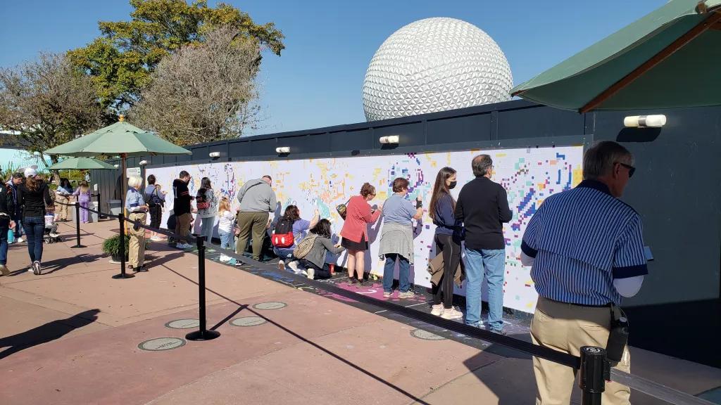 A group of people painting a large paint by numbers mural on a wall