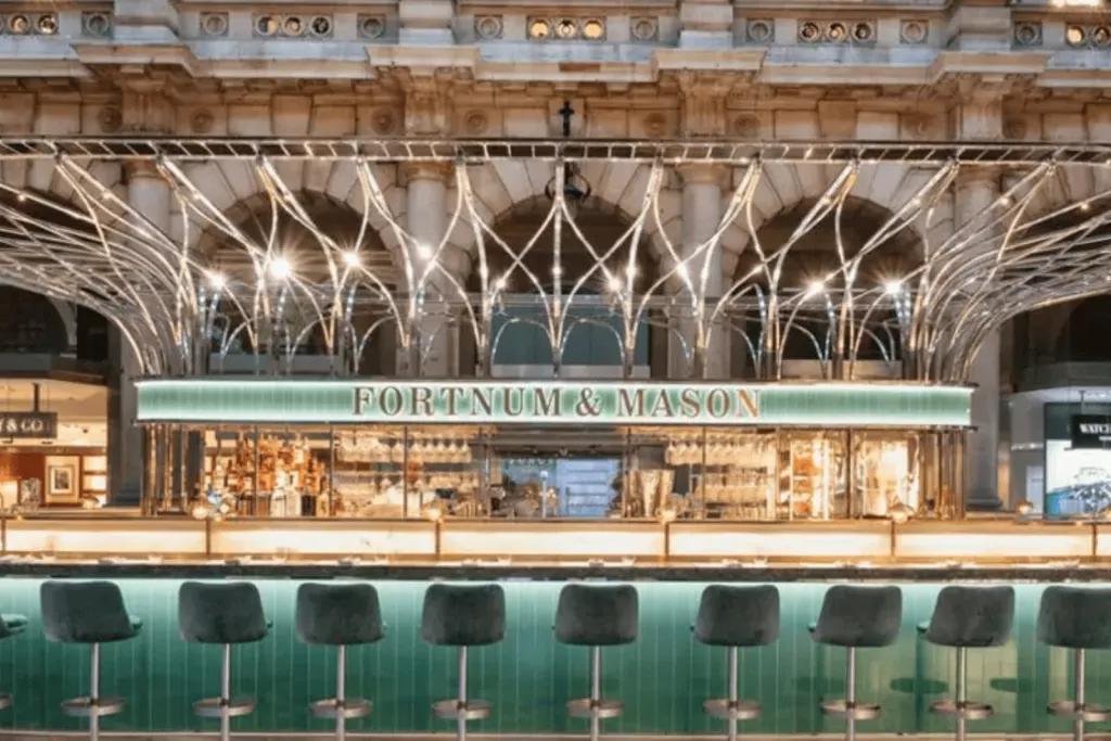 A jewel coloured bar lit up with gold accents featuring the name Fortum and Masons