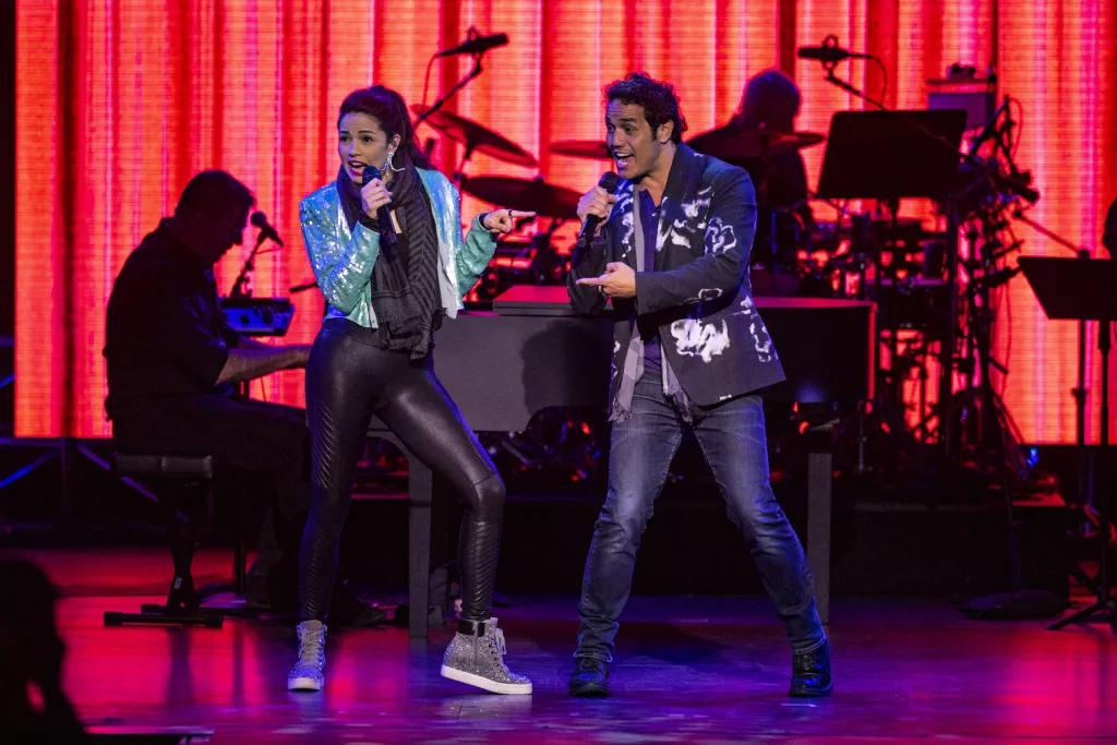 Two performers singing on a stage