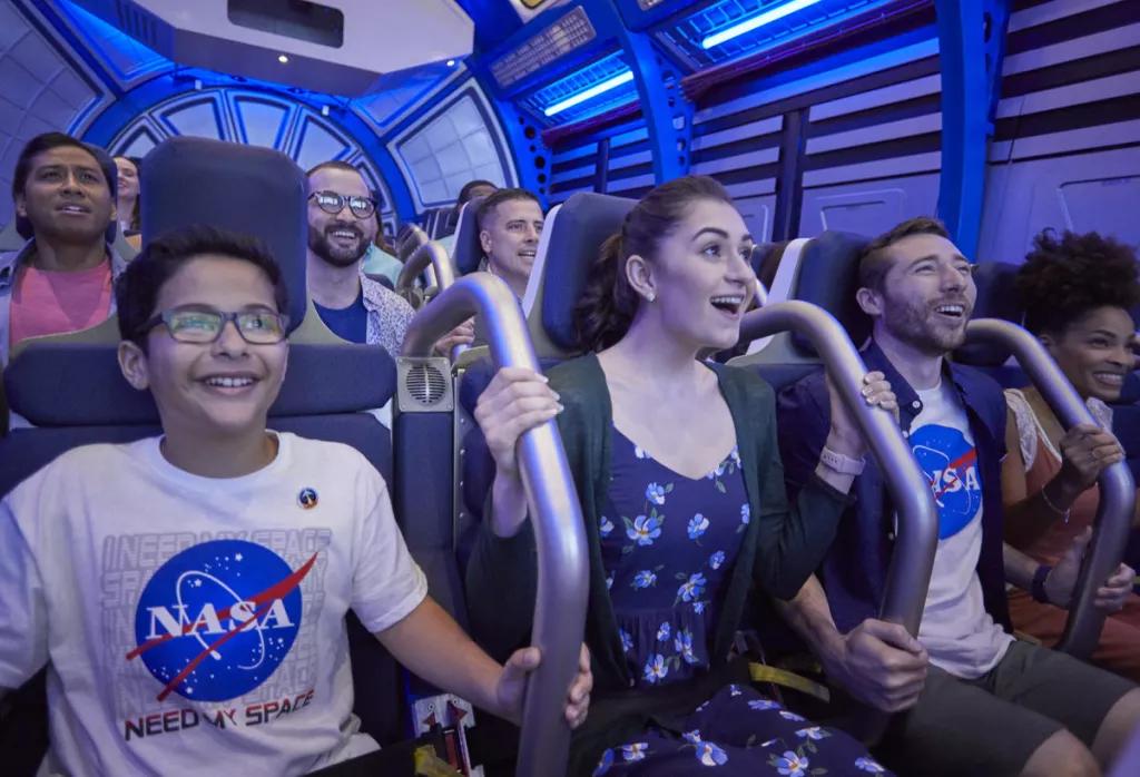 Multiple guests smiling while on a simulator ride designed to look like the inside of a space shuttle
