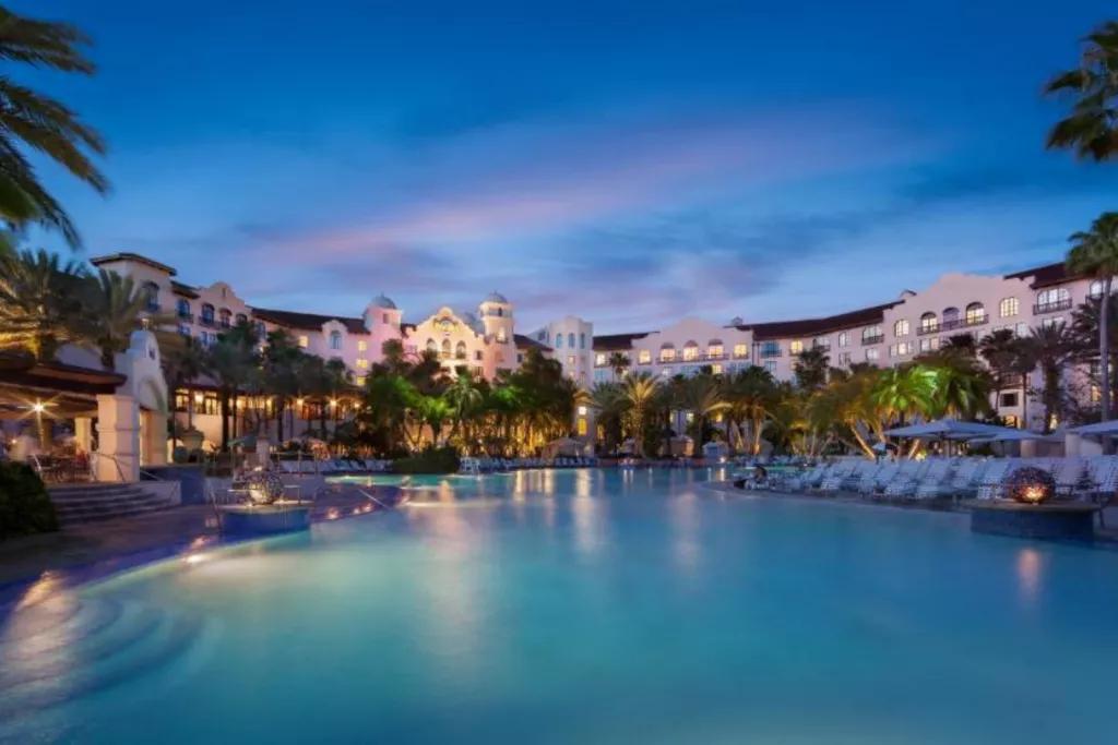 A large pool in front of a hotel in the evening