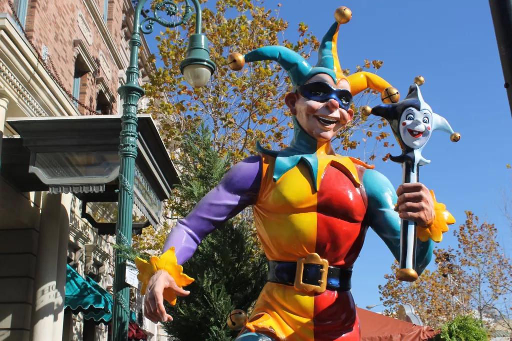A statue of a jester dressed in a bright multicoloured costume