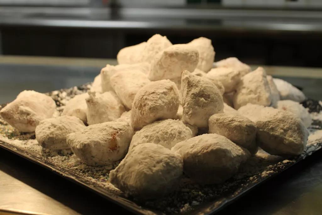 A large pile of beignets covered in powdered sugar
