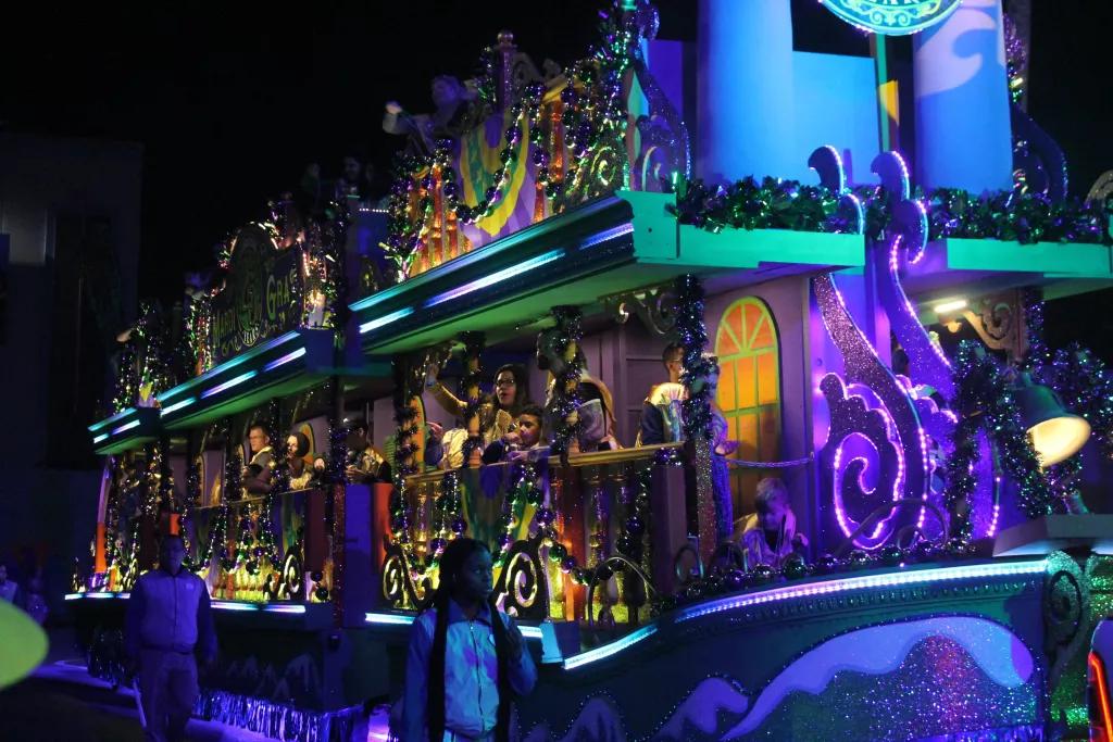 A group of people on a parade float covered in large beads and glittery decorations