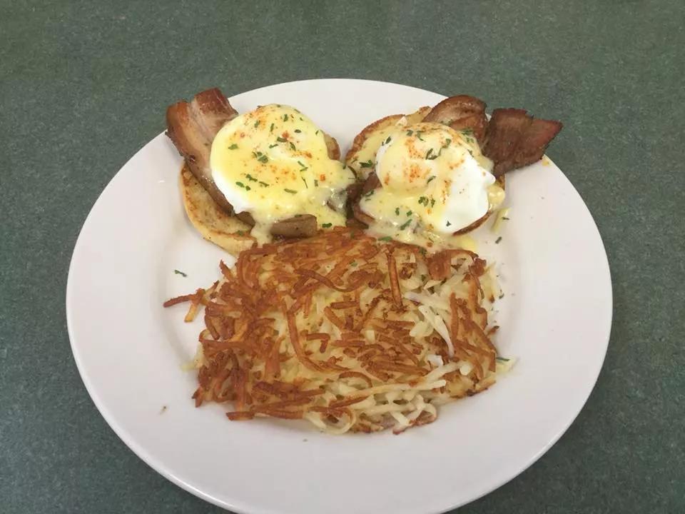 A plate of maple glazed pork belly eggs benedict and hashbrowns