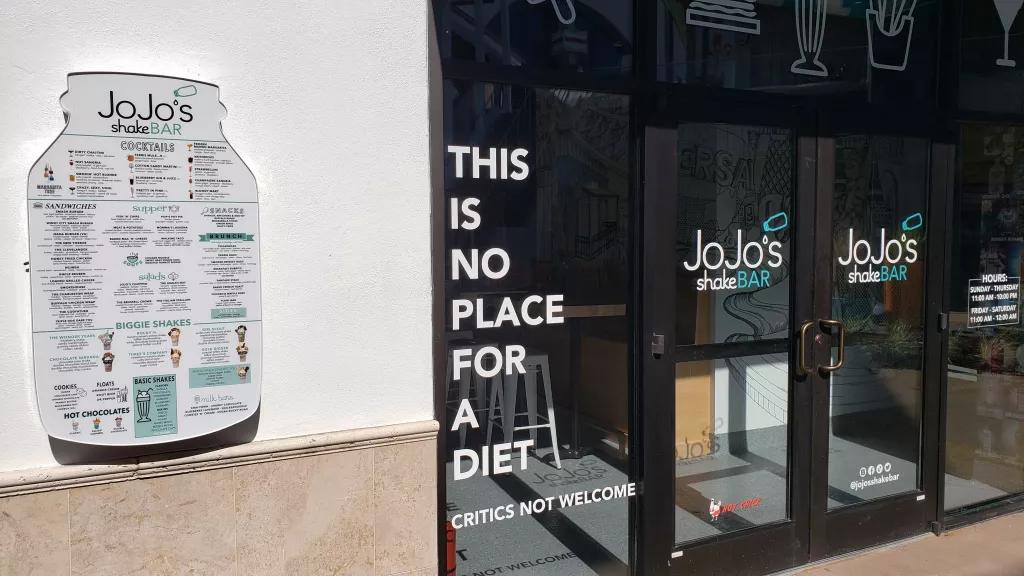 The door of JoJo's ShakeBar reading "This is no place for a diet"