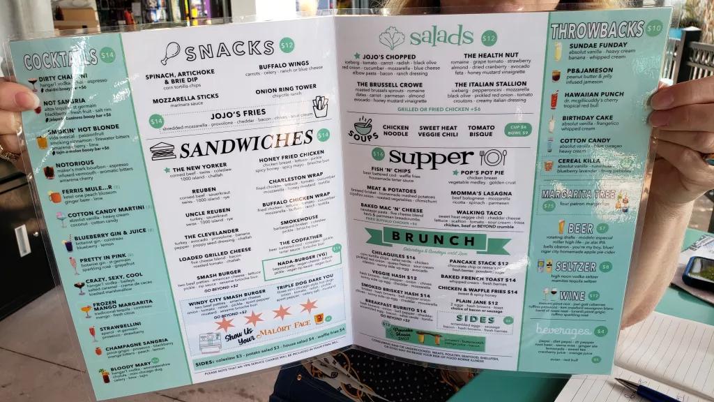An open menu detailing the snacks, sandwiches, salads, dinner and brunch options available at JoJo's 