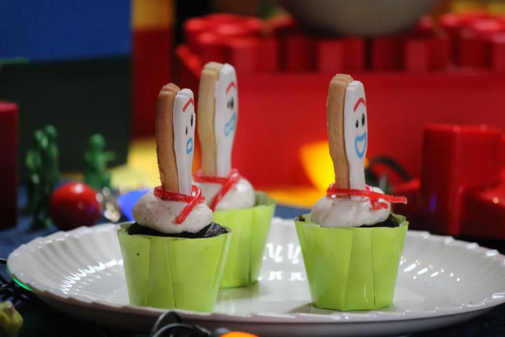 3 chocolate cupcakes topped with a cookie designed to look like Forky from Toy Story