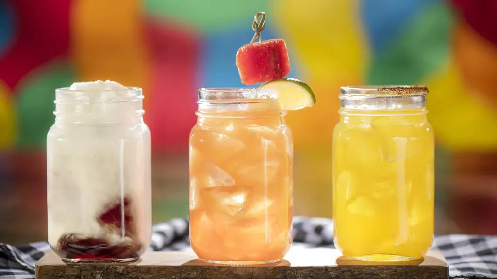 3 mason jars filled with different coloured cocktails
