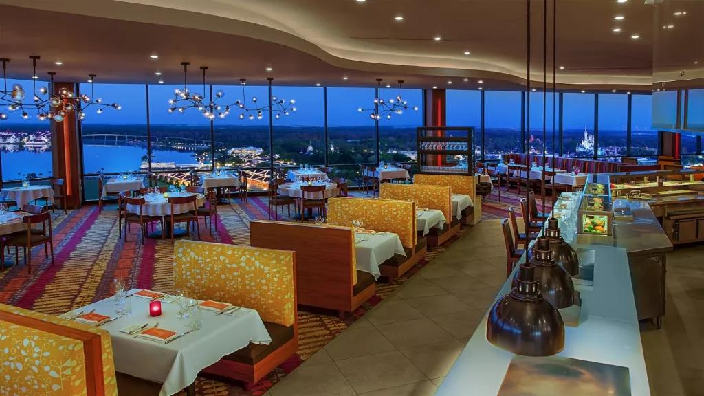 An empty restaurant with rows of booth seating and large floor to ceiling windows in the background