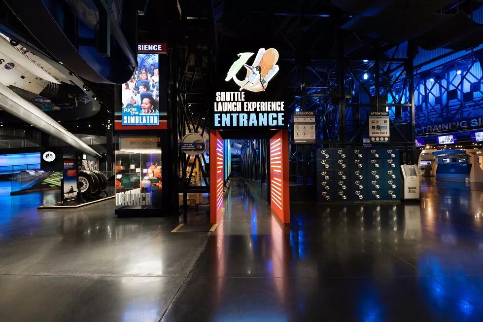 The entrance to the Space Launch Experience featuring a lit up sign above a doorway