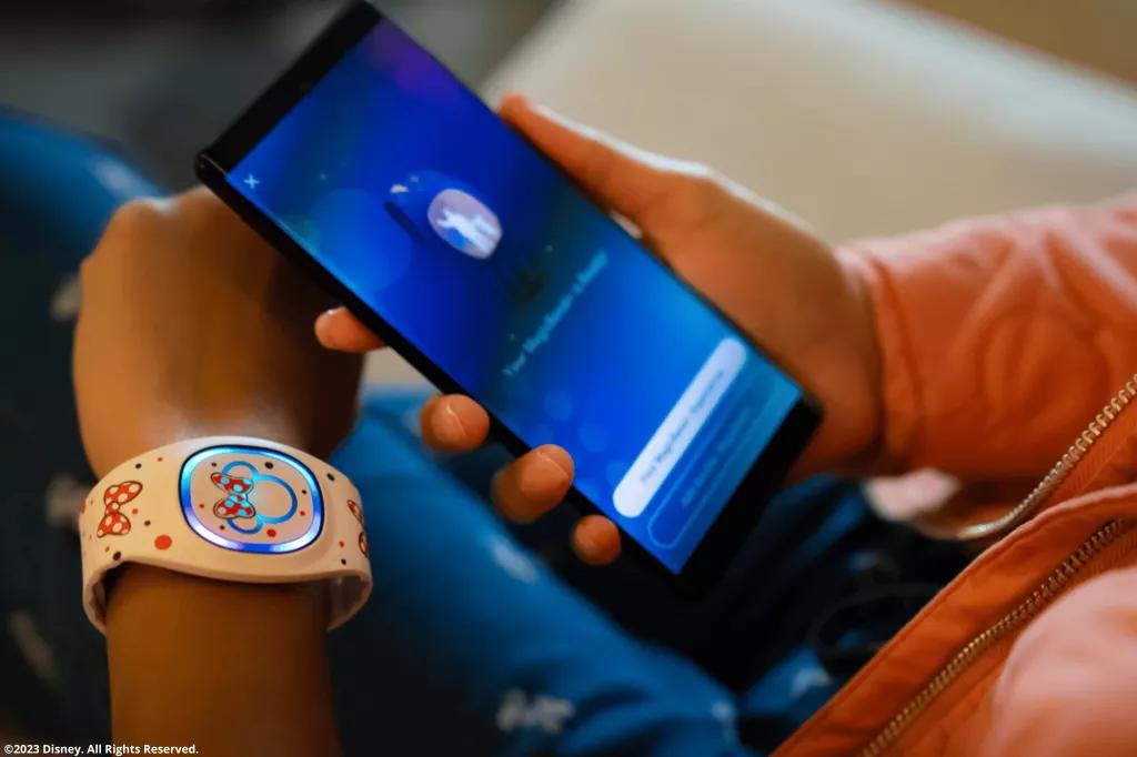 Disney Park Besucher mit Disney band und Disney Magic Mobile App