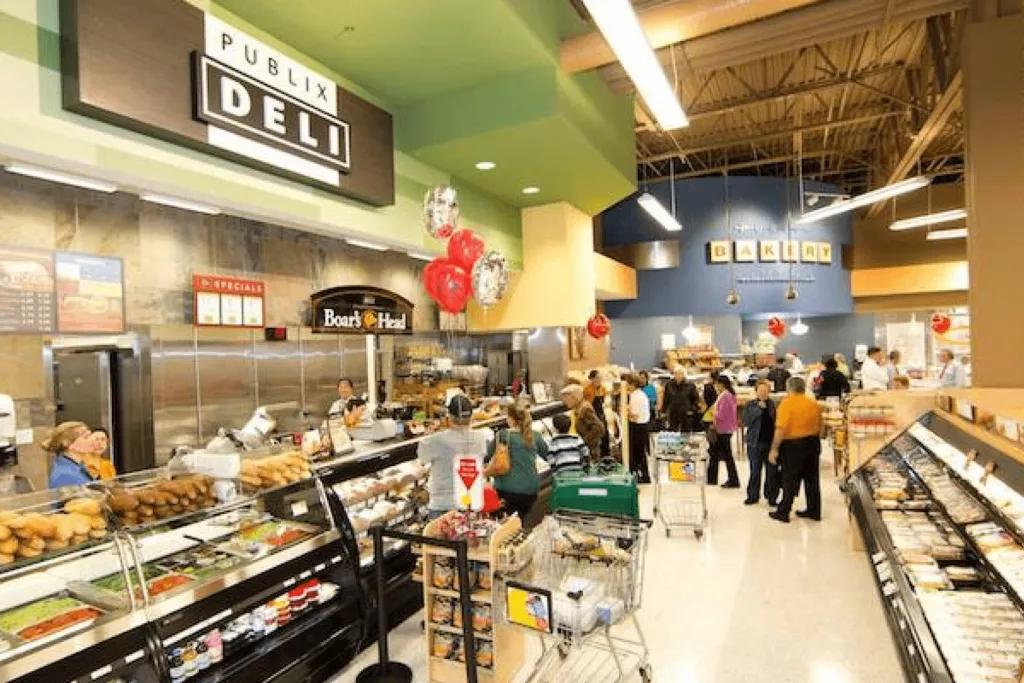 The inside of a grocery store with customers shopping at a deli counter