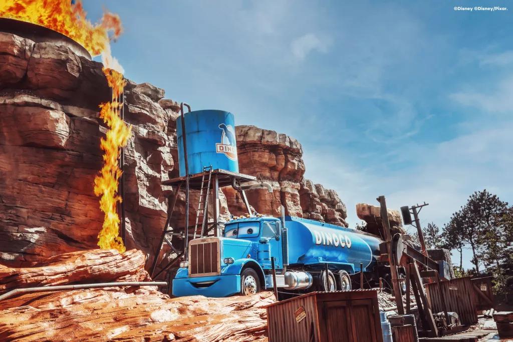 A cartoon style oil tanker in a canyon that is starting to light on fire 