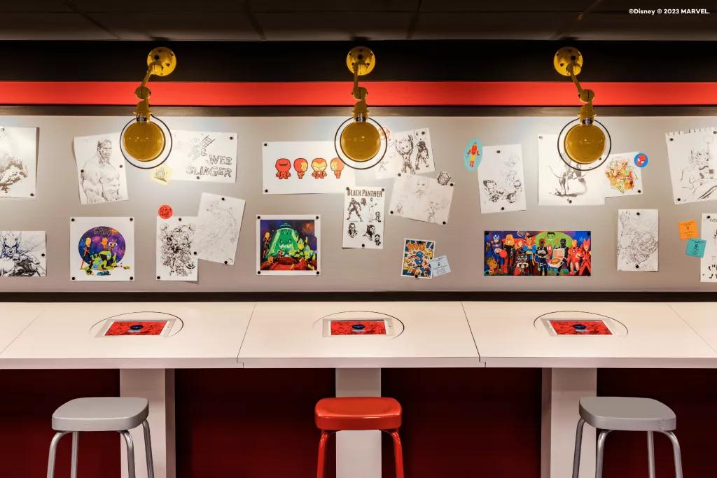 A row of desks against a wall covered in cartoon drawings of Marvel characters