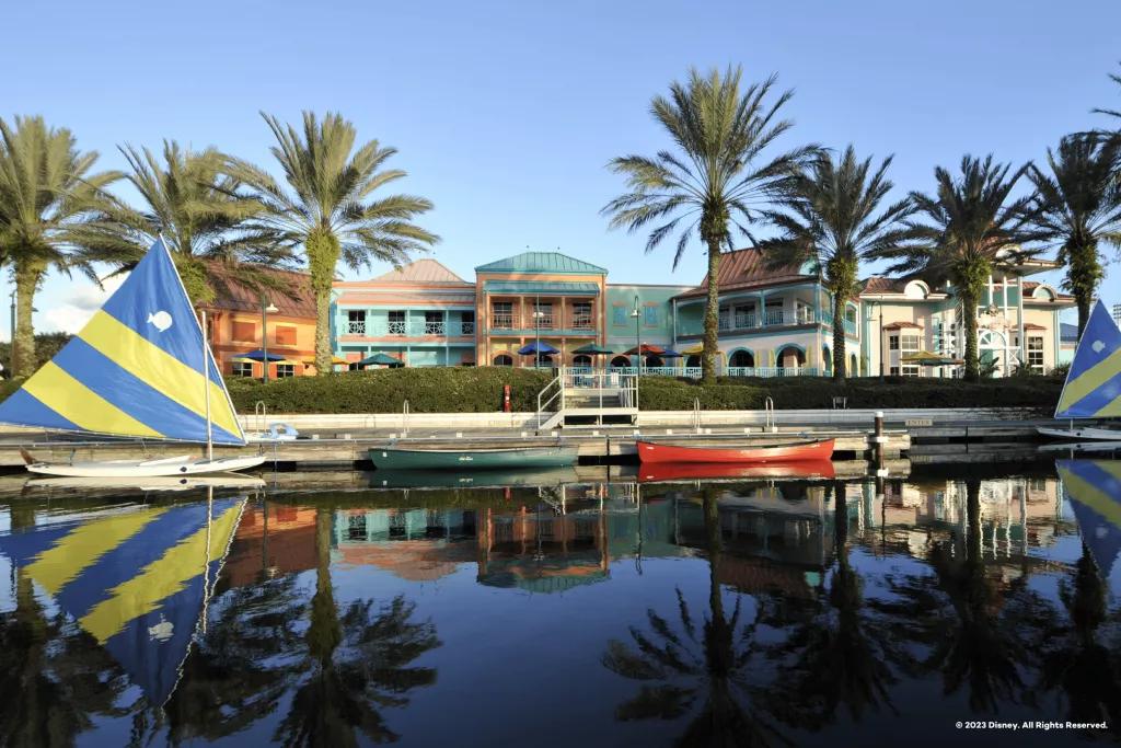 A marina in front of brightly painted buildings and palm trees