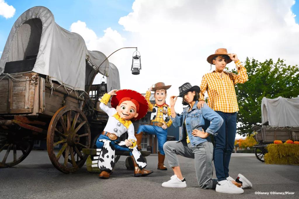 Two guests posing with Woody and Jessie from Toy Story wearing cowboy hats