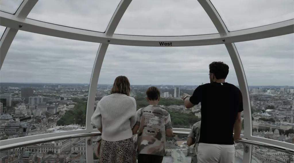 Eine vierköpfige Familie steht im London Eye und blickt über London