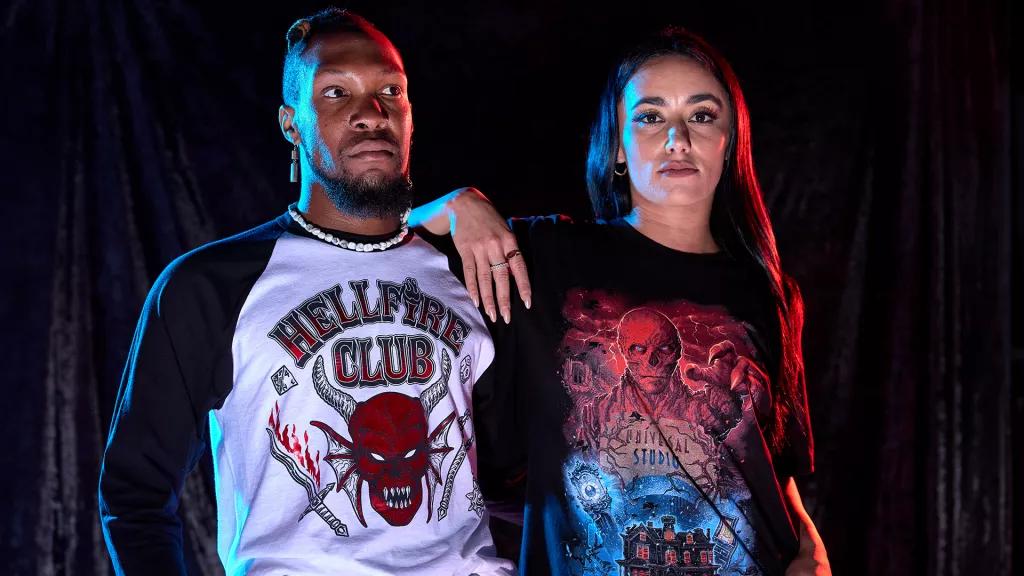A man wearing a Hellfire Club tshirt and a woman wearing a Stranger Things 4 tshirt