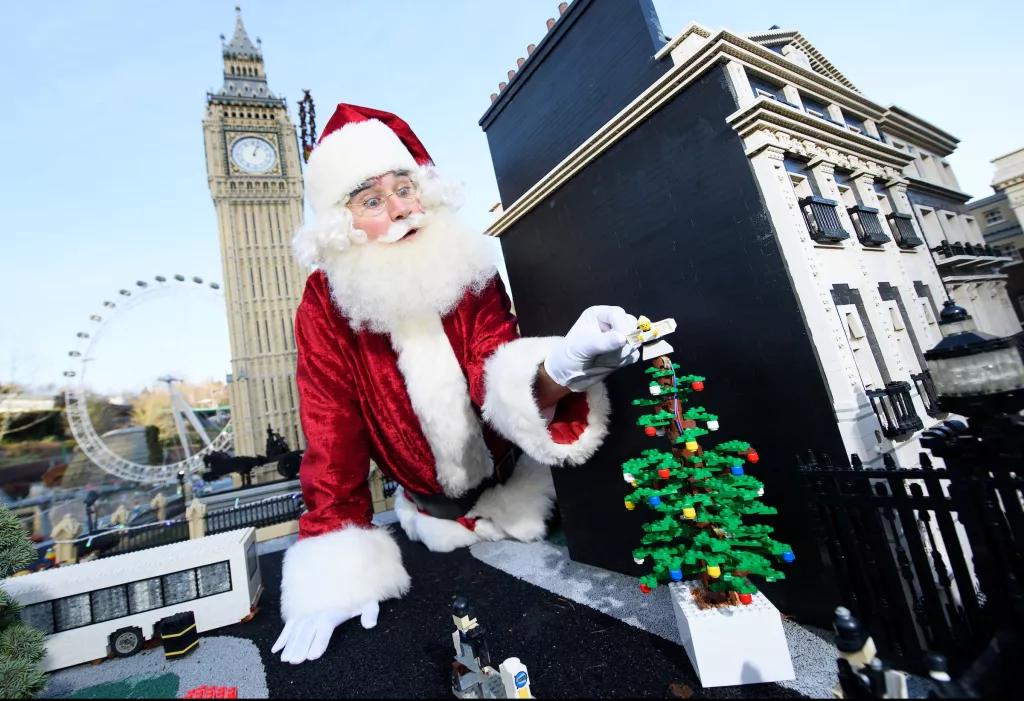 Father Christmas adding a Lego Christmas tree to a Lego model of London