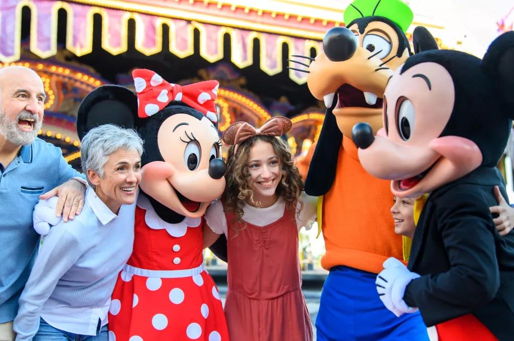 A family meeting Mickey, Minnie and Goofy in front of the carousel